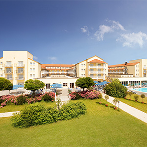 Außenansicht eines Hotels mit Garten und Poolanlage